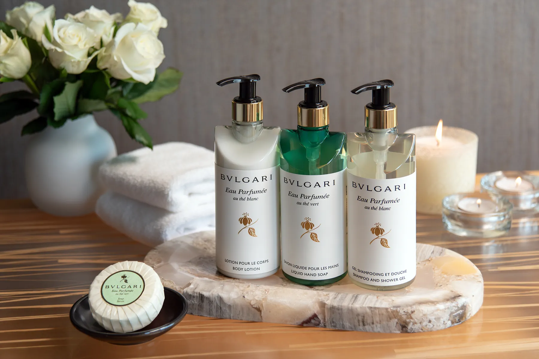 A luxurious trio of Bulgari bath products along with a bar of soap.